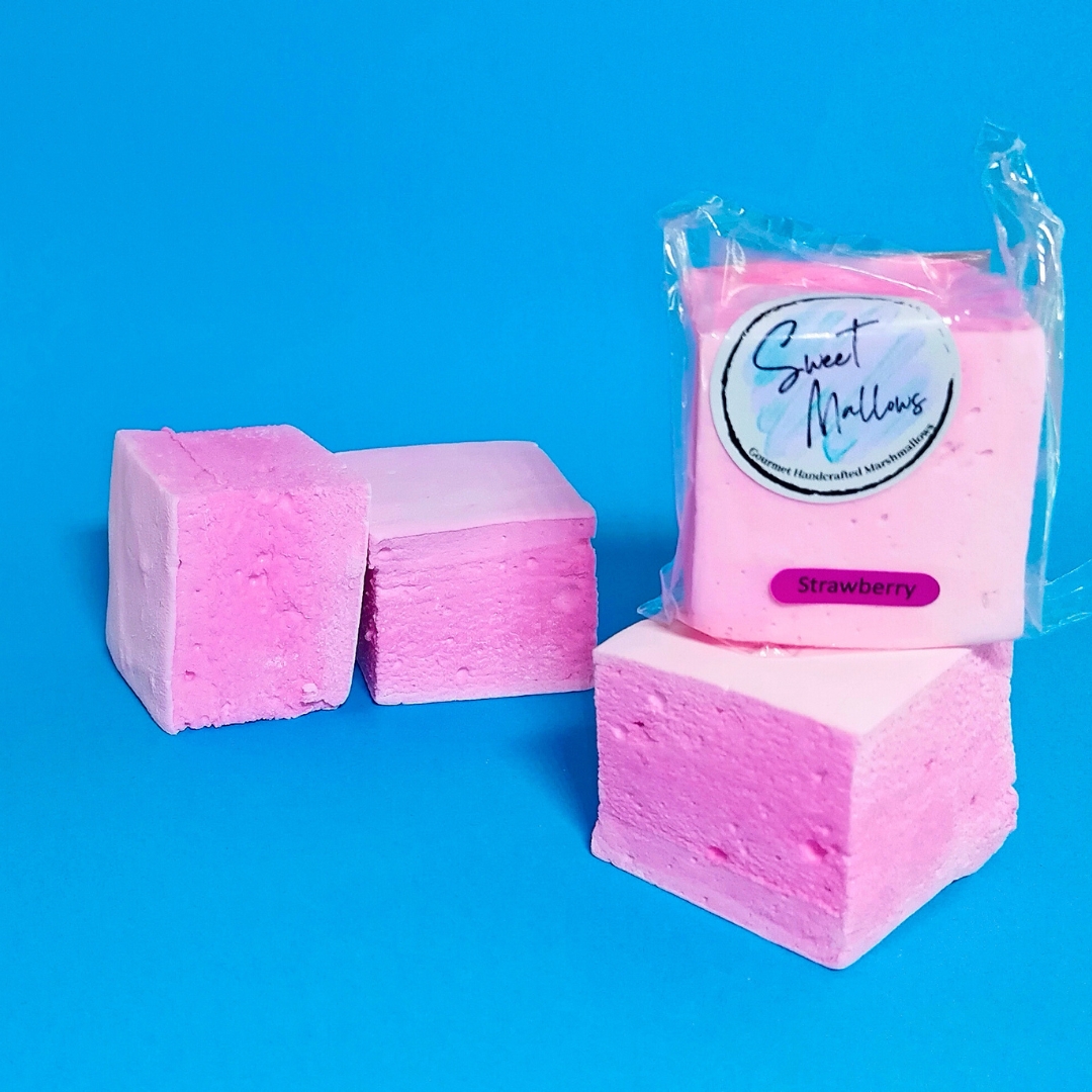 Pink strawberry marshmallows on a bright blue background